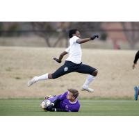 Cordell Cato of OKC Energy FC leaps over the Louisville City FC keeper in a preseason game