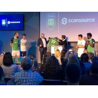 Greenville Triumph Head Coach John Harkes presents Scansource CEO Mike Bauer with the team's new jersey