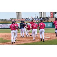 The Pensacola Blue Wahoos mob Jaylin Davis at first base after his game-winning hit
