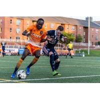 Lansing Ignite FC attacker Nathan Lewis (left) battles for possession