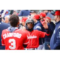 Shed Long of the Tacoma Rainiers receives congratulations in the dugout