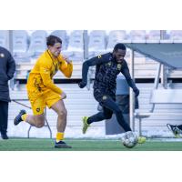 Junior Etou of Pittsburgh Riverhounds SC (right) vs. West Virginia University