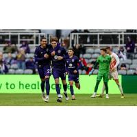 Louisville City FC teammates congratulate Wilson Harris after a goal