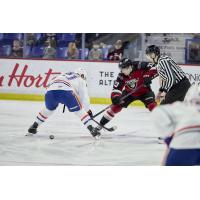 Vancouver Giants centre Brett Olson (right) faces off with the Spokane Chiefs