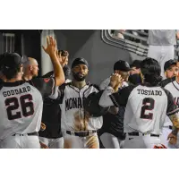 Isiah Gilliam exchanges high fives in the Kansas City Monarchs dugout