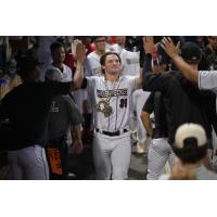 Cam Fisher receives high fives from the Fayetteville Woodpeckers in the dugout