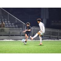 Pittsburgh Riverhounds midfielder Jackson Walti (left) vs. Duquesne University