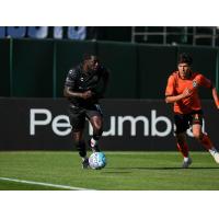 Oakland Roots' Neveal Hackshaw and Orange County SC's Nico Benalcázar in action