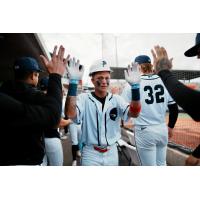 Pensacola Blue Wahoos exchange high fives in the dugout